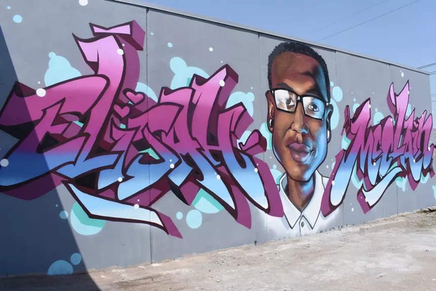 Mural of Elijah McClain with block letters on either side.