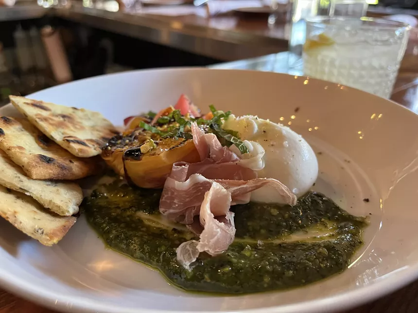 green sauce on a plate with meat, cheese and bread