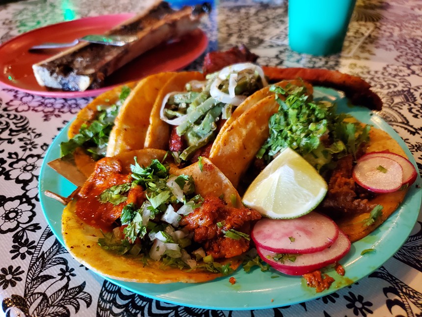 tacos on a plate with a slice of lime and radish slices