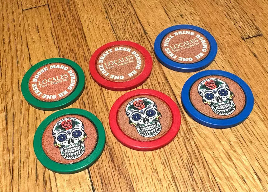 six plastic chips laid out on a wooden table