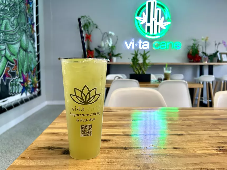 a beverage i a plastic cup on a wooden table