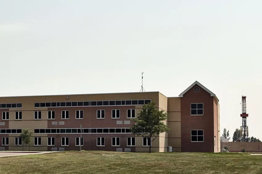 A red and yellow brick building sits on top of a grassy lawn.