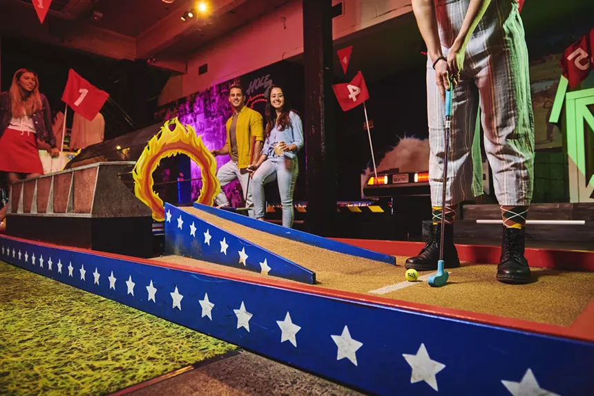 people playing putt-putt golf inside
