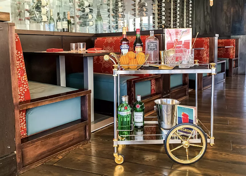 restaurant with booth and cart with bottles on it