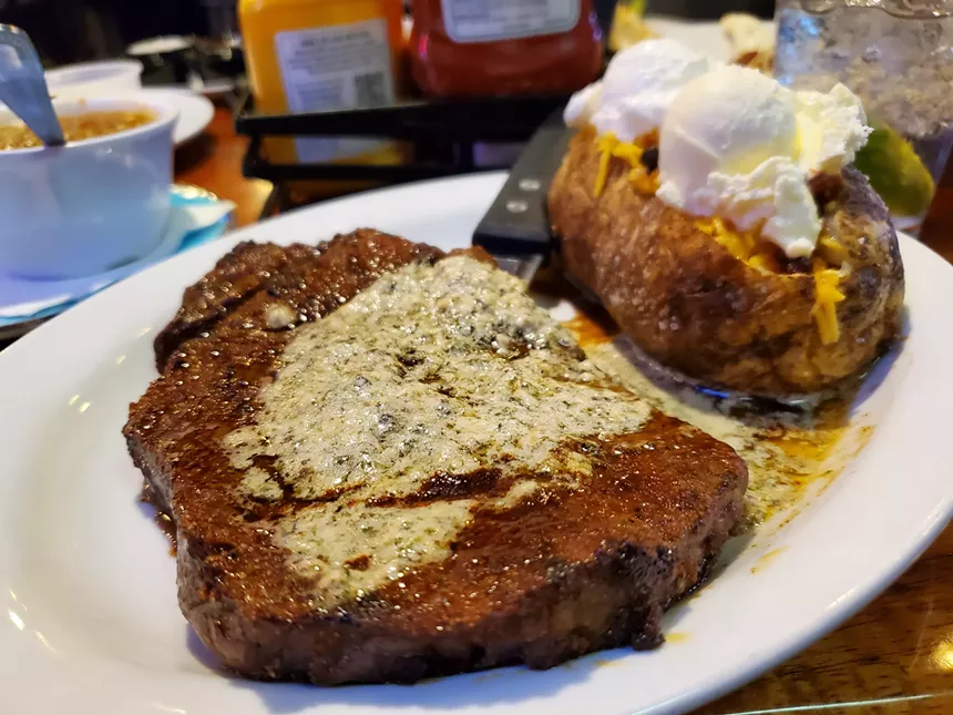 a steak next to a baked potato