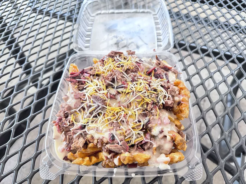 Waffle fries topped with smoked brisket, cheese, and queso