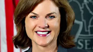 A woman with brown hair and blue eyes smiles at the camera.