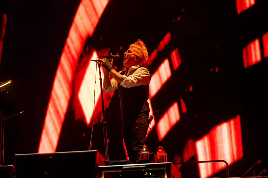 blonde man sings into microphone