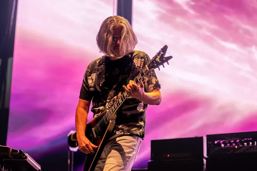 man playing a guitar on stage