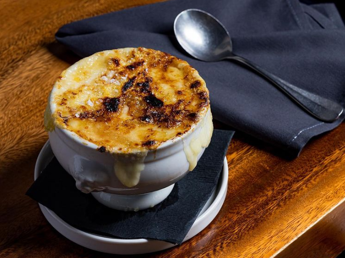broiled cheese on top of a bowl of soup