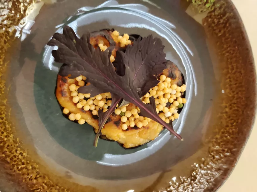 a dish with a purple leaf on top