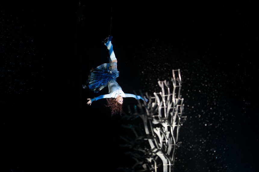 woman in blue dress hanging upside down from one foot