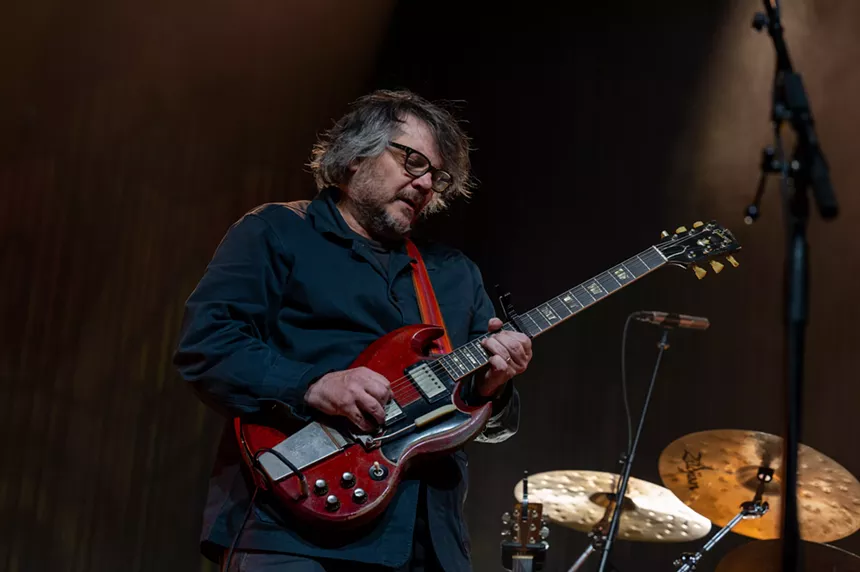 man playing red guitar in black button down shirt