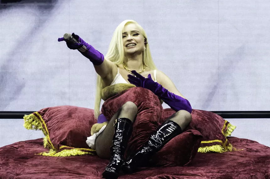 blonde woman  sitting on red velvet bed
