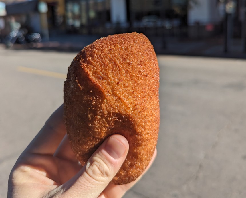 hand holding a fried croquette