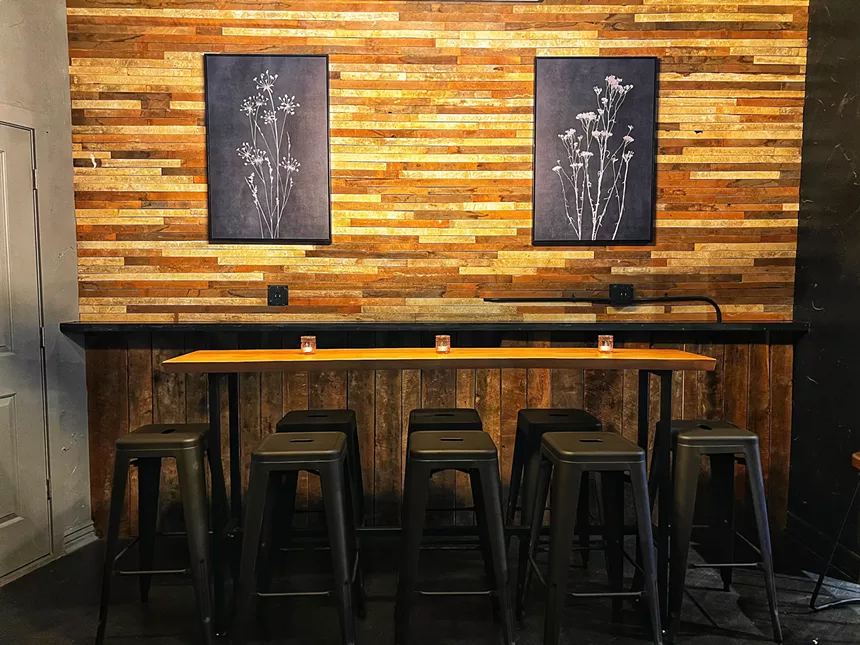 a wooden table with black stools