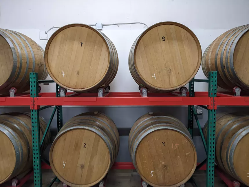 Barrels of beer on racks.