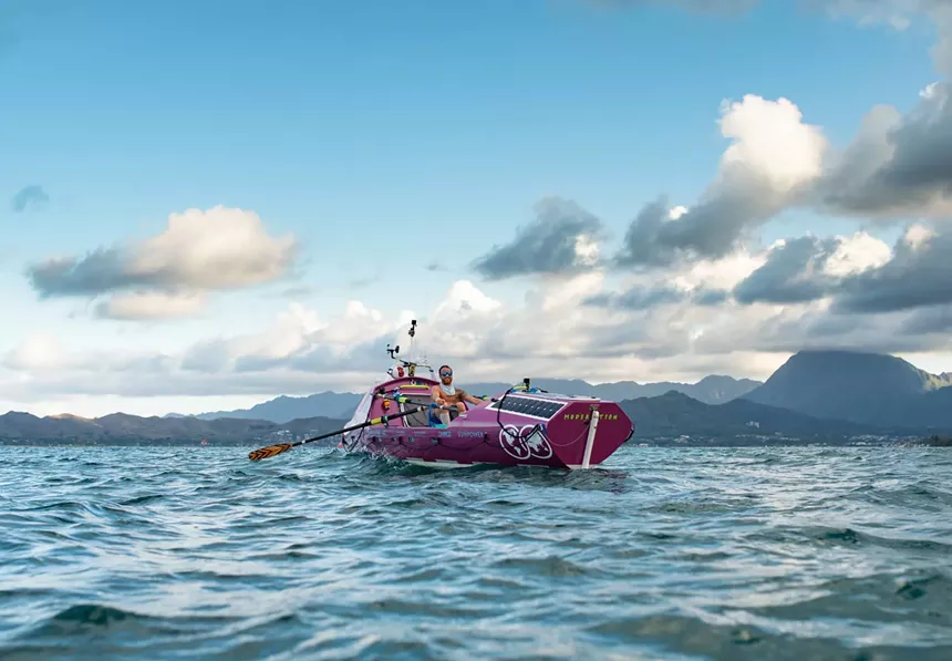 man rowing boat on ocean