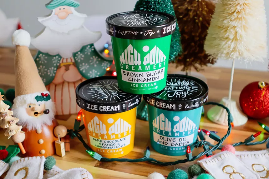 three pints of ice cream surrounded by Christmas decor.