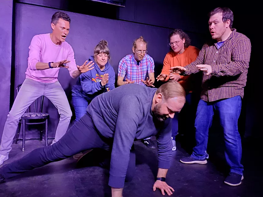 improv actors with man on floor.