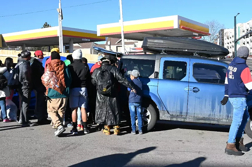 Venezuelan migrants flock around a truck as someone donates tacos.