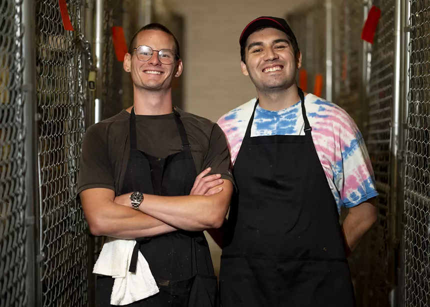 two men in black aprons