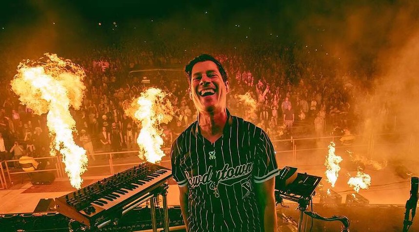 man on a stage surrounded by flames