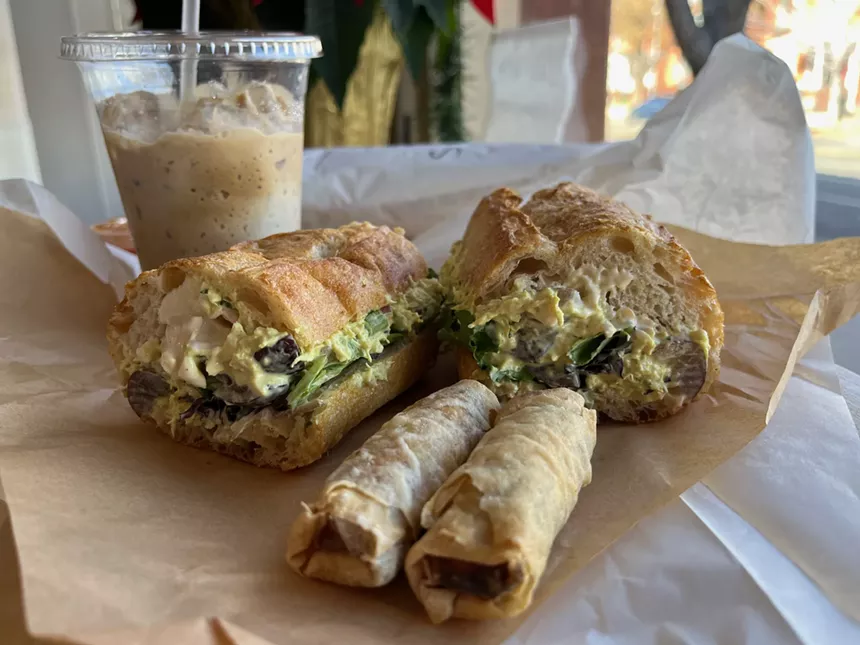 egg rols, a sandwich and a cup of iced coffee