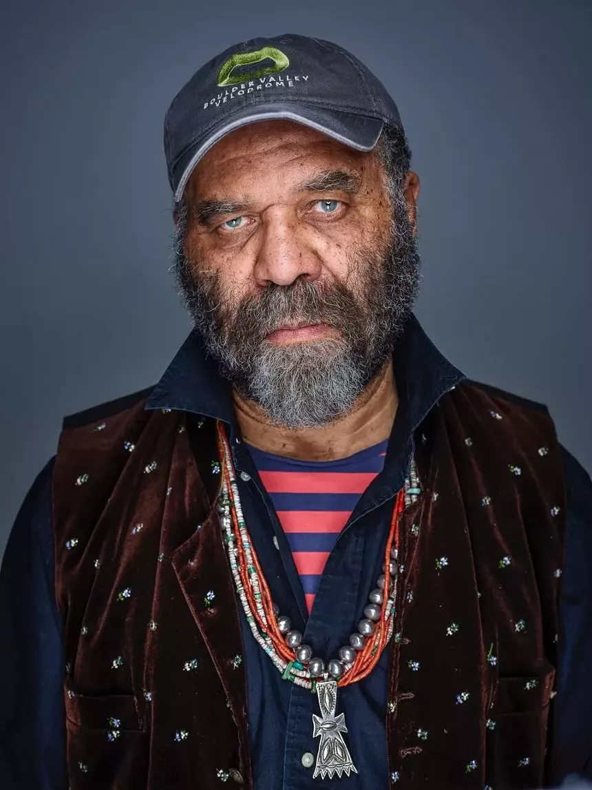 black man with blue eyes and beard wearing a hat