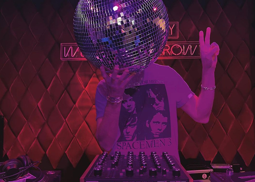 DJ holding a disco ball to obscure their face