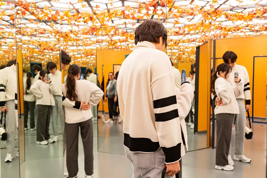 people in a room with orange leaves on the ceiling.