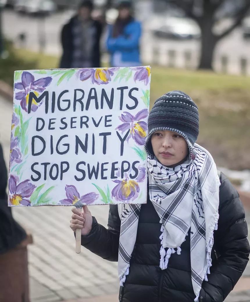 women in scarf holding sign