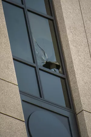 A broken window on the seventh floor of the Ralph L. Carr Colorado Judicial Center, visible from the street below.