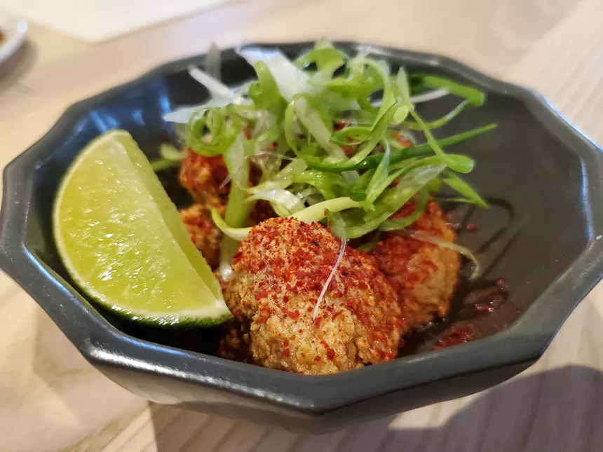 fried sweetbreads in a bowl with a slice of lime