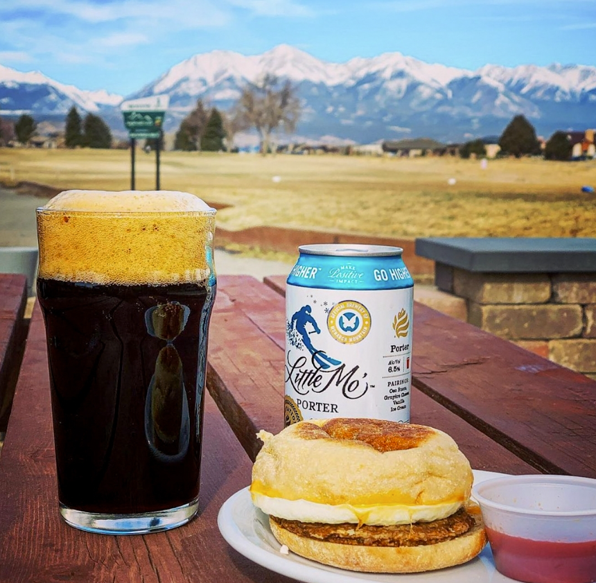 Dark beer and food with mountains in the background.