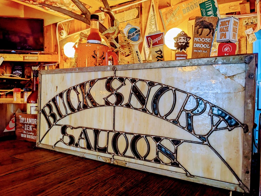 a glass sign that says Bucksnort Saloon