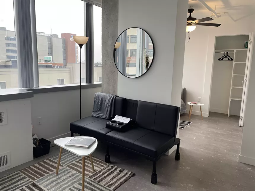 A room with a couch and mirror.