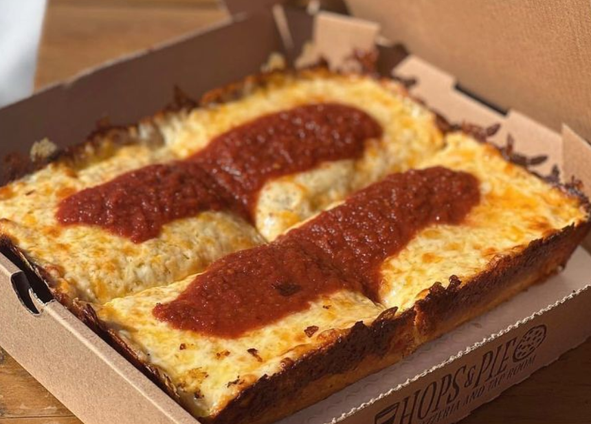 a square pizza with sauce on top