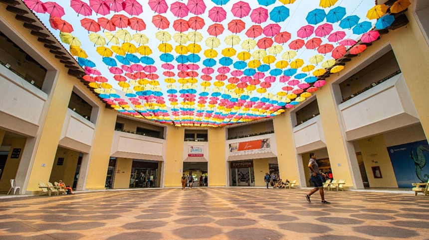 plaza with colorful umbrellas hanging overhead