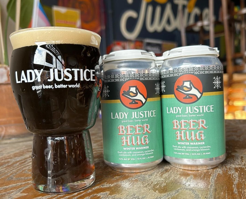 Cans of beer next to a pint glass.
