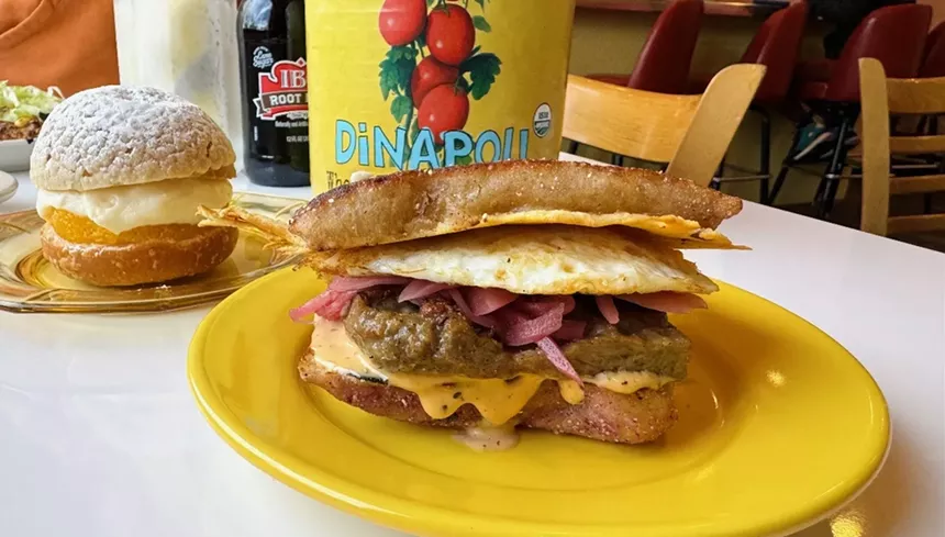a breakfast sandwich on a yellow plate