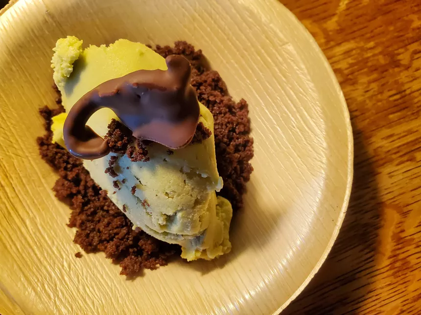 A chocolate-covered scorpion on top of avocado ice cream.