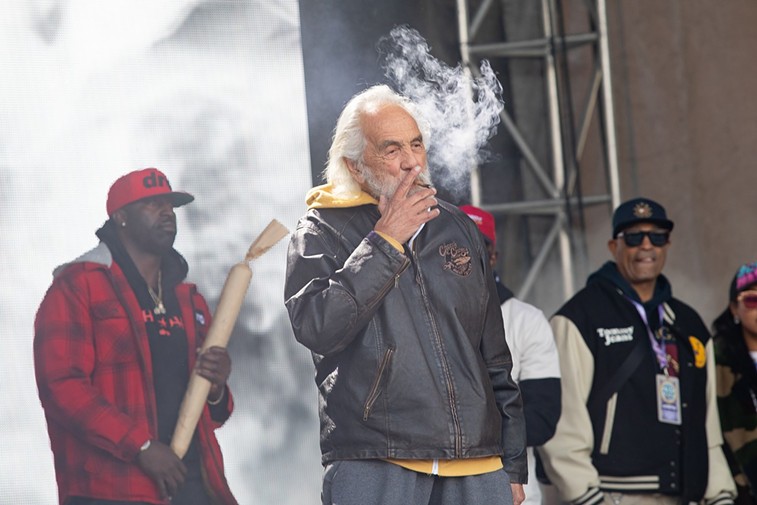 Tommy Chong smokes a joint on stage at the Denver 4/20 festival