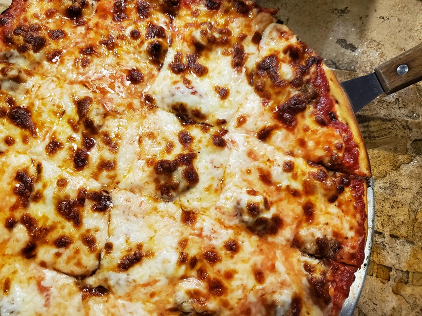 a round, square-cut cheese and sausage pizza