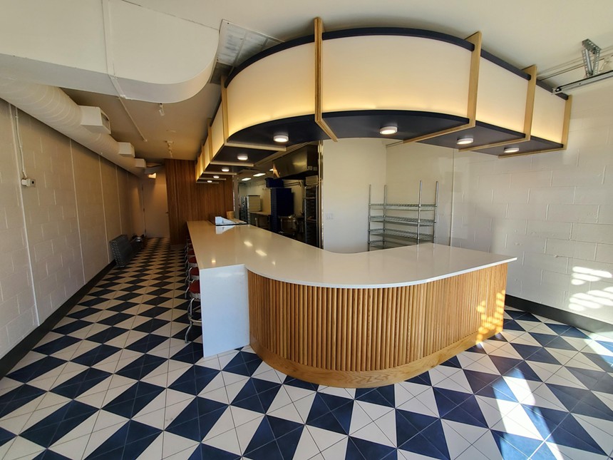 interior of a bagel shop with a counter and checkered floors