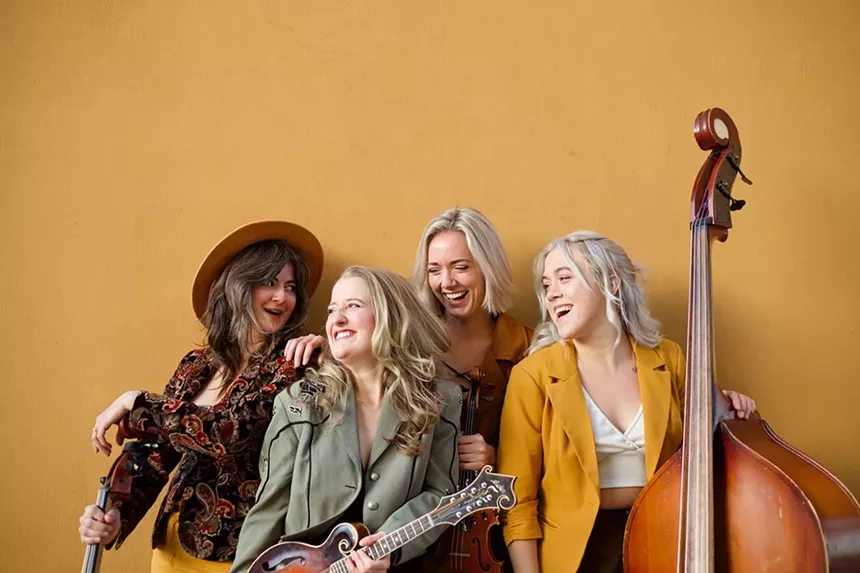 four women smiling with instruments