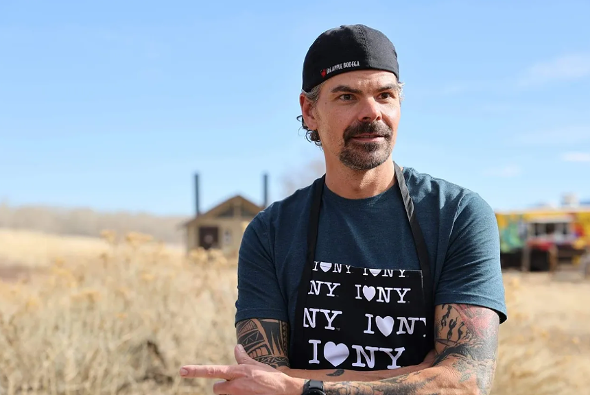 a man in a backward hat, t-shirt and apron