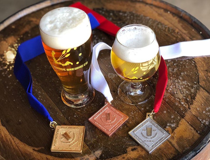 Two beers with competition medals on the table.