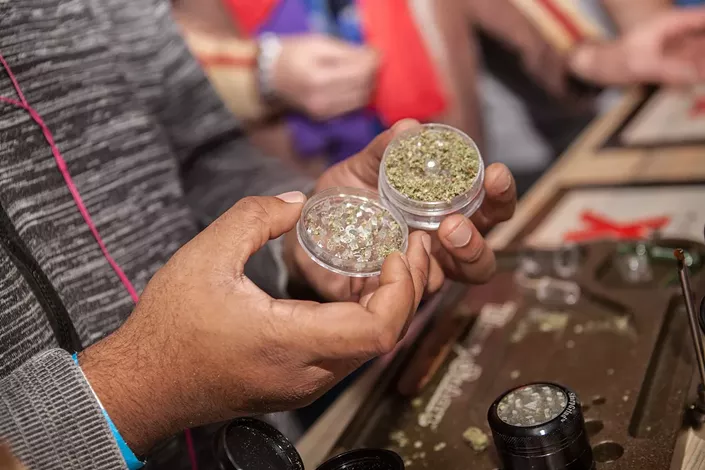 Man holds aluminum weed grinder