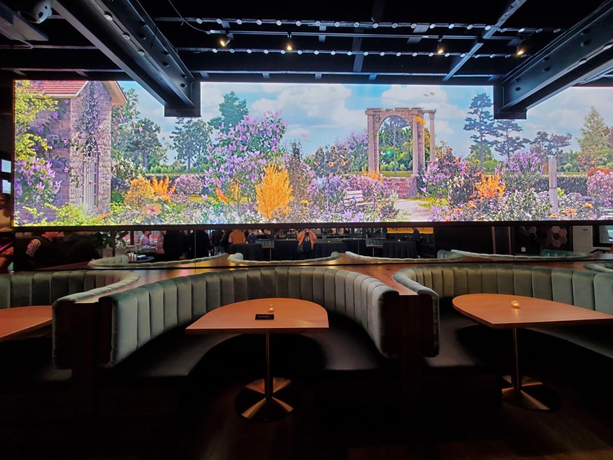 booths inside a restaurant with floral projection on the wall